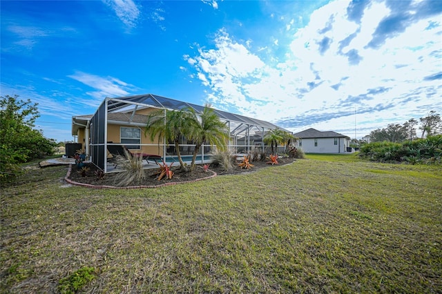 rear view of property featuring a yard and a lanai