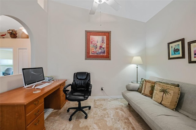 215 Australian Dr, Rotonda West, FL 33947 - home office featuring arched walkways, a ceiling fan, baseboards, lofted ceiling, and light stone finish floors