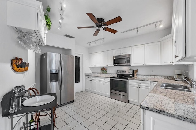 kitchen featuring rail lighting, appliances with stainless steel finishes, sink, and white cabinets