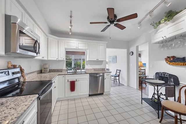 kitchen with white cabinetry, sink, light stone countertops, and appliances with stainless steel finishes