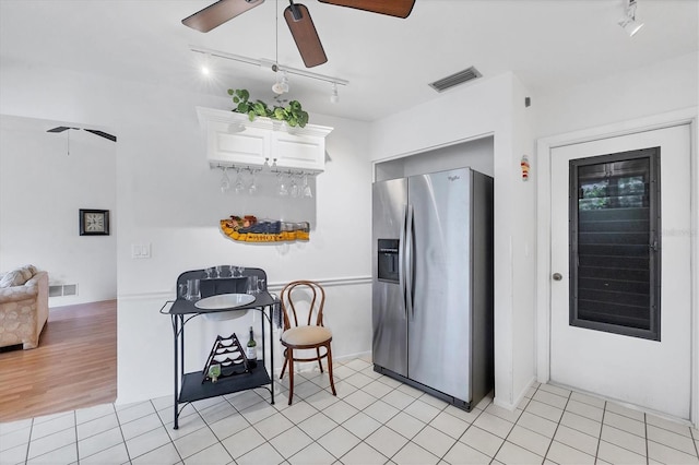 kitchen with white cabinetry, ceiling fan, stainless steel fridge, and light tile patterned flooring