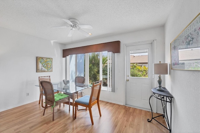 dining area featuring ceiling fan, a textured ceiling, and light wood-type flooring