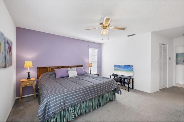 carpeted bedroom featuring a textured ceiling and ceiling fan