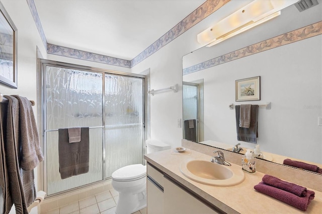 bathroom featuring tile patterned floors, vanity, toilet, and a shower with shower door