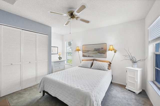 bedroom featuring ceiling fan, a textured ceiling, a closet, and dark colored carpet