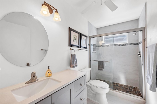 bathroom featuring ceiling fan, vanity, toilet, and a shower with door