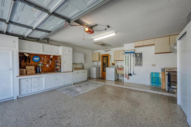 garage with a garage door opener, electric panel, and washing machine and clothes dryer