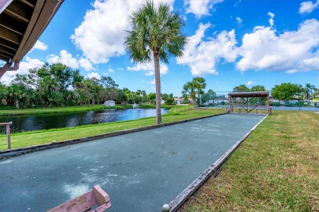 surrounding community featuring a water view and a lawn