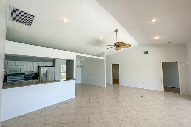 unfurnished living room with lofted ceiling, light tile patterned floors, sink, and ceiling fan