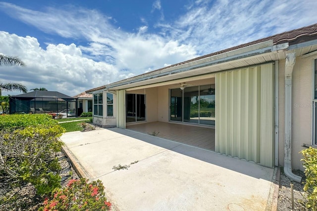 back of property featuring a patio area and glass enclosure