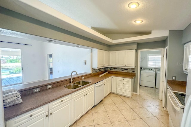 kitchen featuring sink, white appliances, backsplash, independent washer and dryer, and white cabinets