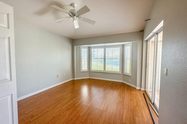 empty room featuring ceiling fan and light hardwood / wood-style flooring