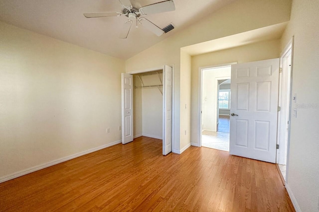 unfurnished bedroom with vaulted ceiling, light hardwood / wood-style floors, ceiling fan, and a closet