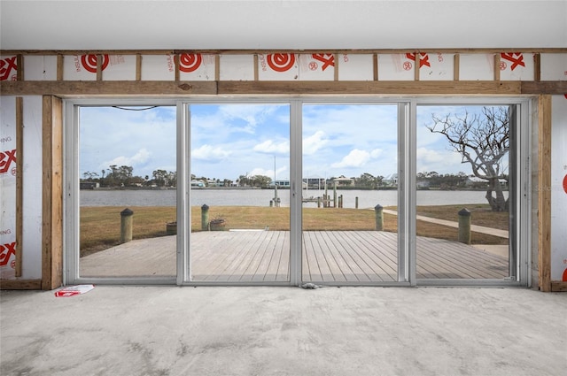 doorway to outside with concrete flooring, a water view, and a healthy amount of sunlight