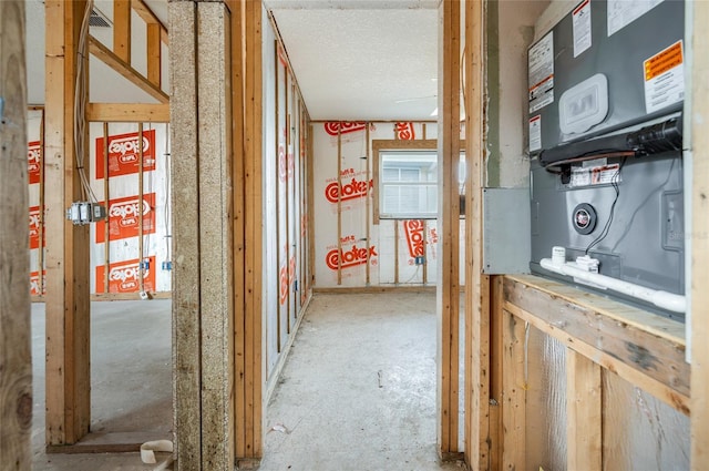 hall featuring heating unit and a textured ceiling