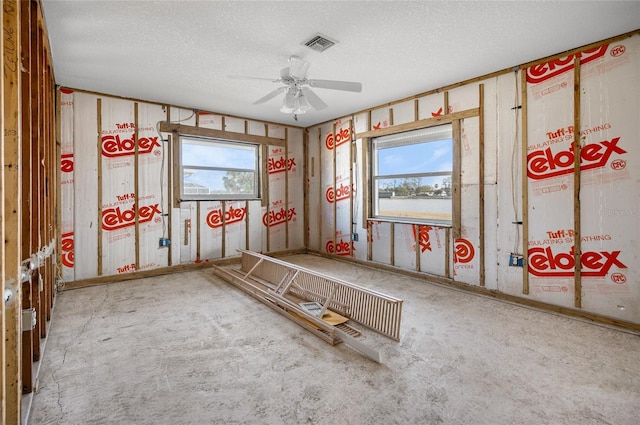 misc room featuring ceiling fan, a textured ceiling, and a wealth of natural light