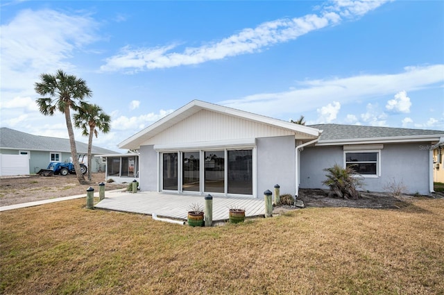 rear view of house with a wooden deck and a yard