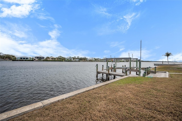 view of dock with a water view and a lawn