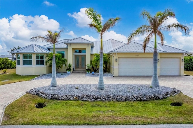 view of front of home featuring a garage, a front lawn, and french doors