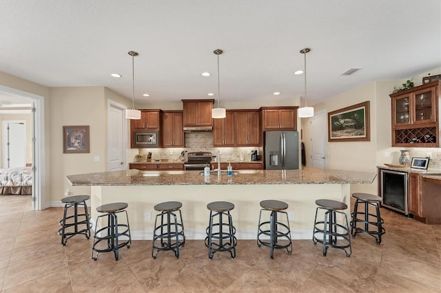 kitchen featuring pendant lighting, a kitchen bar, appliances with stainless steel finishes, and a large island