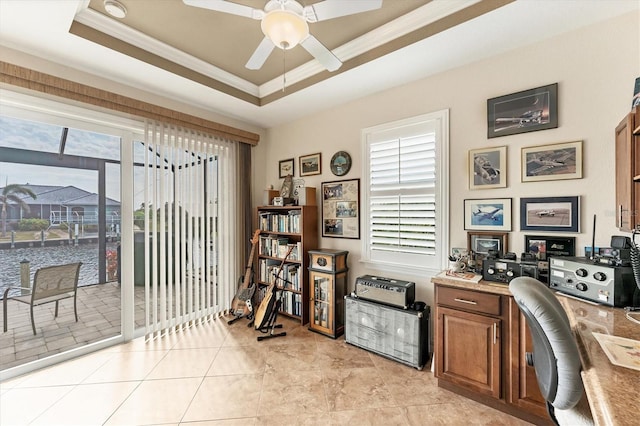 tiled office with ceiling fan, crown molding, and a tray ceiling