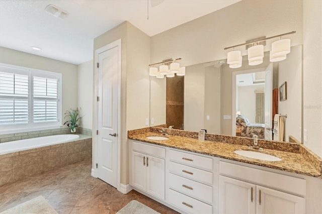 bathroom featuring vanity and tiled bath