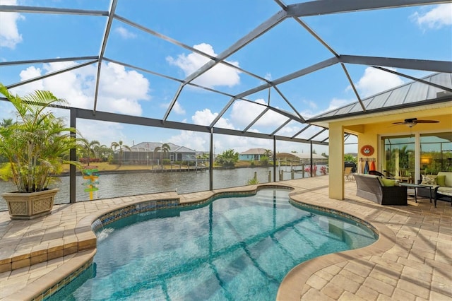 view of pool with a patio area, a lanai, an outdoor living space, and a water view