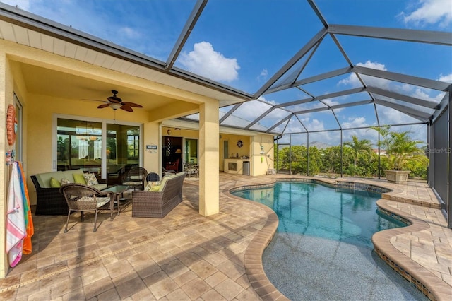 view of pool with an outdoor living space, ceiling fan, a patio area, and a lanai