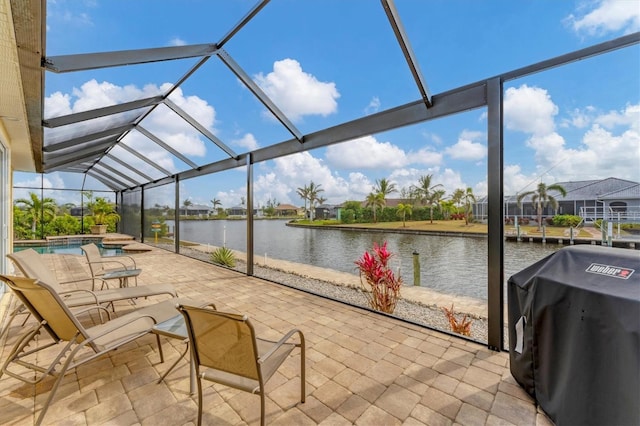 view of patio with a swimming pool with hot tub, a lanai, a grill, and a water view