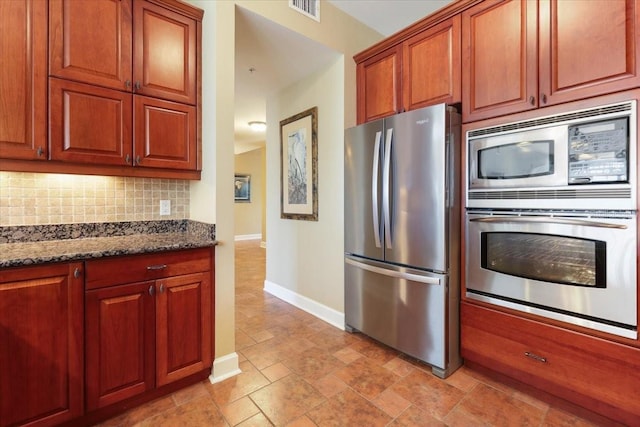 kitchen featuring tasteful backsplash, stainless steel appliances, and dark stone countertops