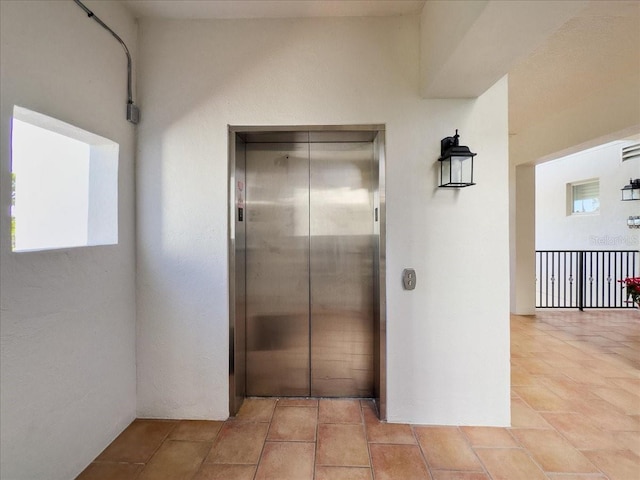 interior space with light tile patterned floors, a wealth of natural light, and elevator