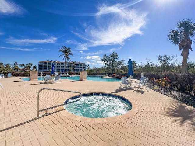 view of pool featuring a hot tub and a patio