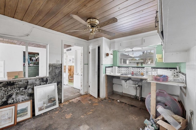 kitchen featuring wooden ceiling, ceiling fan, sink, and concrete flooring