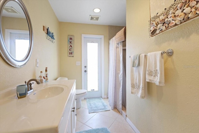 bathroom with tile patterned flooring, vanity, and toilet