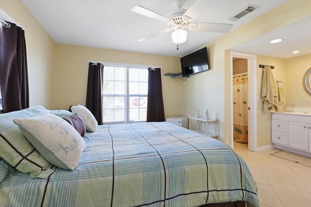 tiled bedroom with ceiling fan and ensuite bath