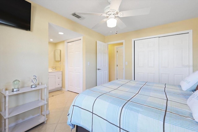 bedroom with light tile patterned floors, ceiling fan, and ensuite bathroom