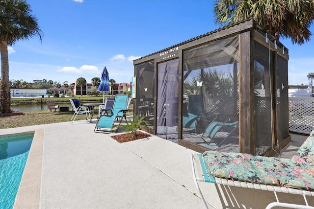 view of pool featuring a patio and a water view