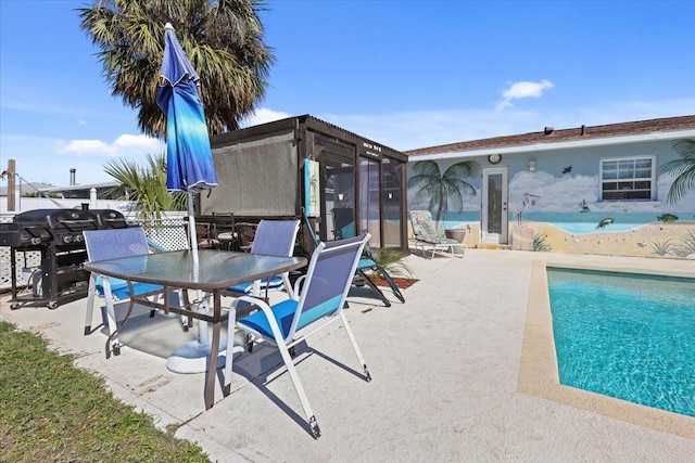 view of pool featuring a grill and a patio