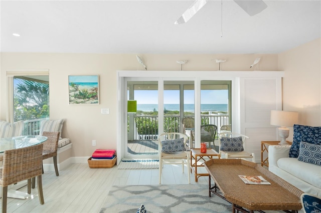 living room with light hardwood / wood-style floors and a water view