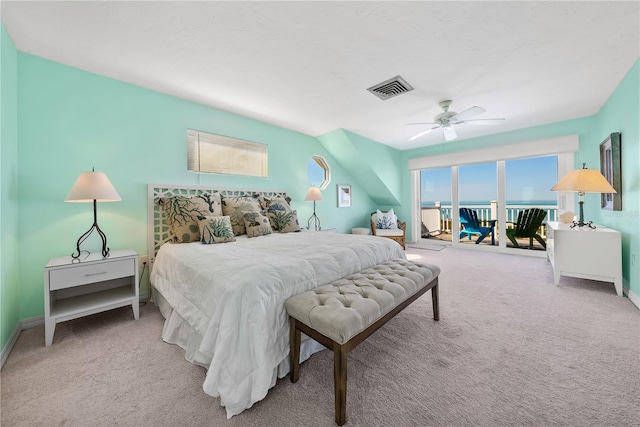 bedroom with a water view, ceiling fan, access to exterior, and light colored carpet