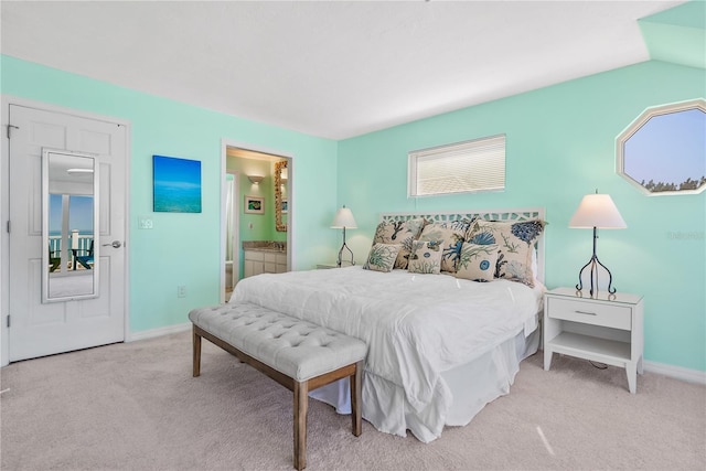 carpeted bedroom featuring connected bathroom and vaulted ceiling