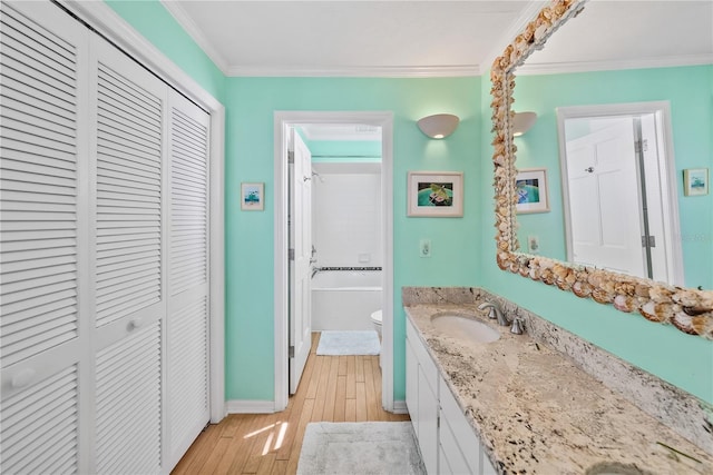 full bathroom with crown molding, tiled shower / bath, wood-type flooring, and vanity