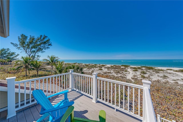 wooden deck featuring a water view and a beach view