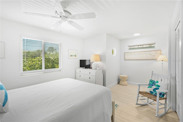 bedroom featuring light wood-type flooring, ceiling fan, and a closet