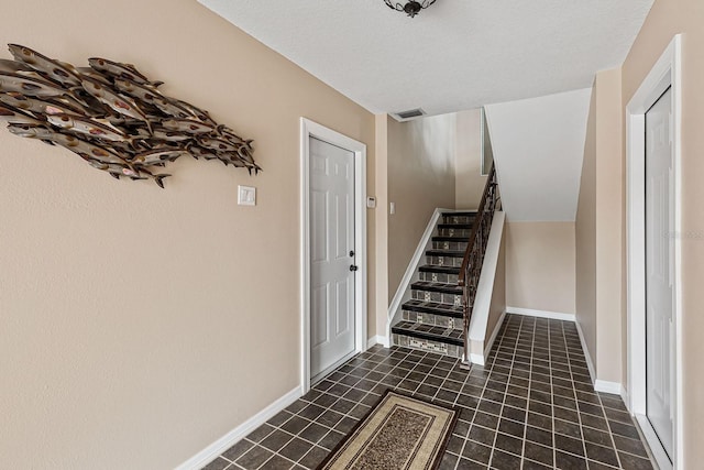 stairs featuring a textured ceiling