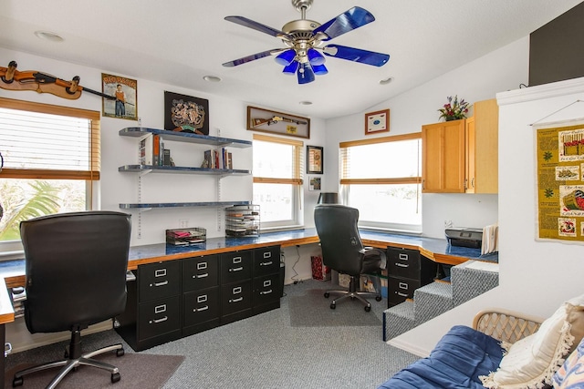 carpeted office space featuring vaulted ceiling and ceiling fan