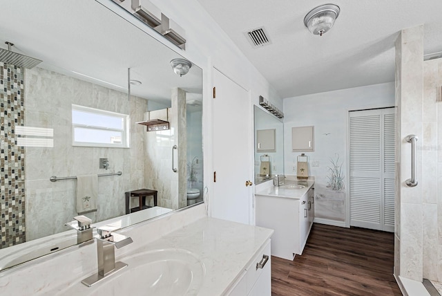 bathroom featuring vanity, hardwood / wood-style floors, and a tile shower