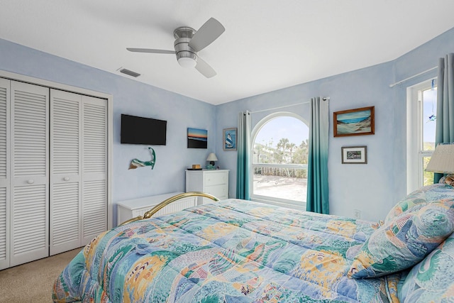 carpeted bedroom with ceiling fan and a closet