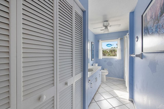 bathroom featuring tile patterned flooring, vanity, ceiling fan, and toilet