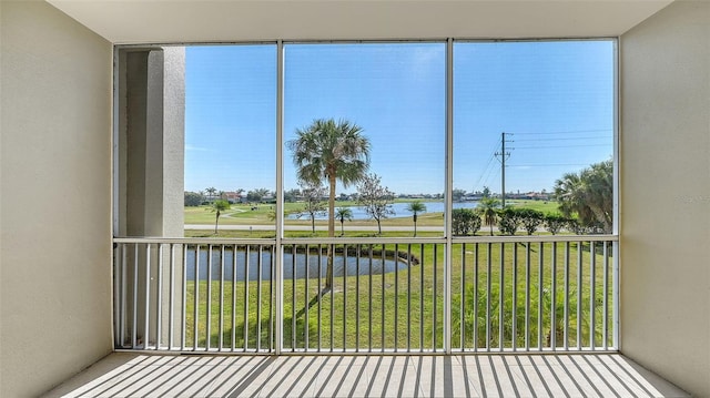 unfurnished sunroom featuring a water view